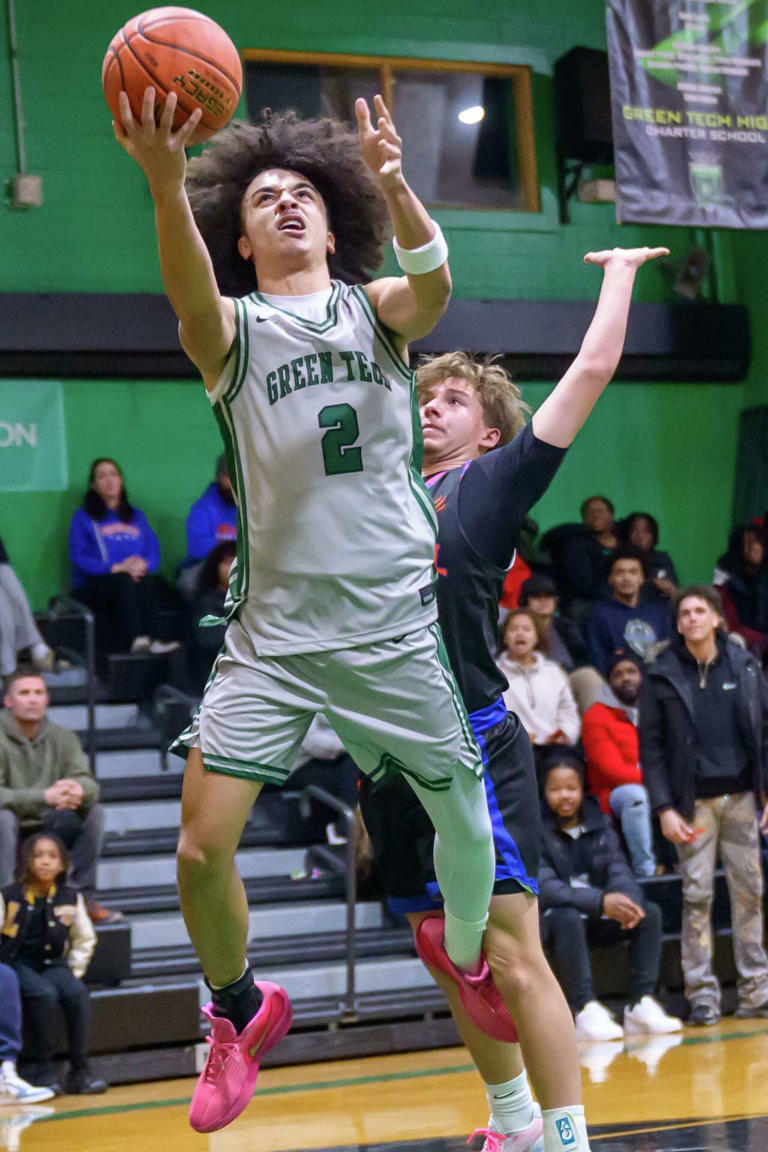 Green Tech Eagles player rising for a contested layup in front of a home crowd