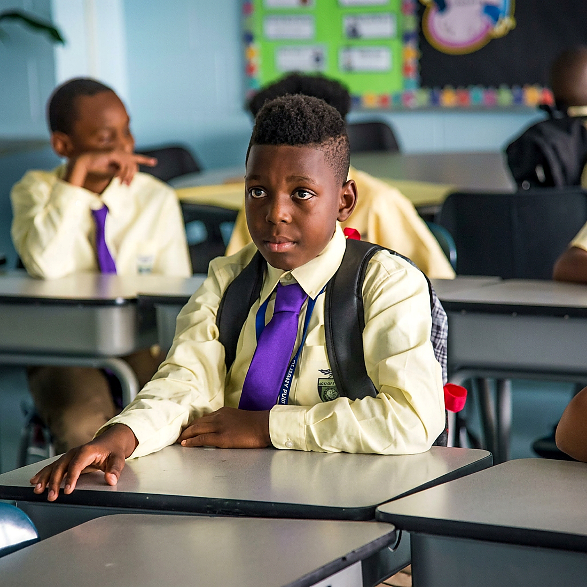 Green Tech High student in uniform seated at a classroom desk