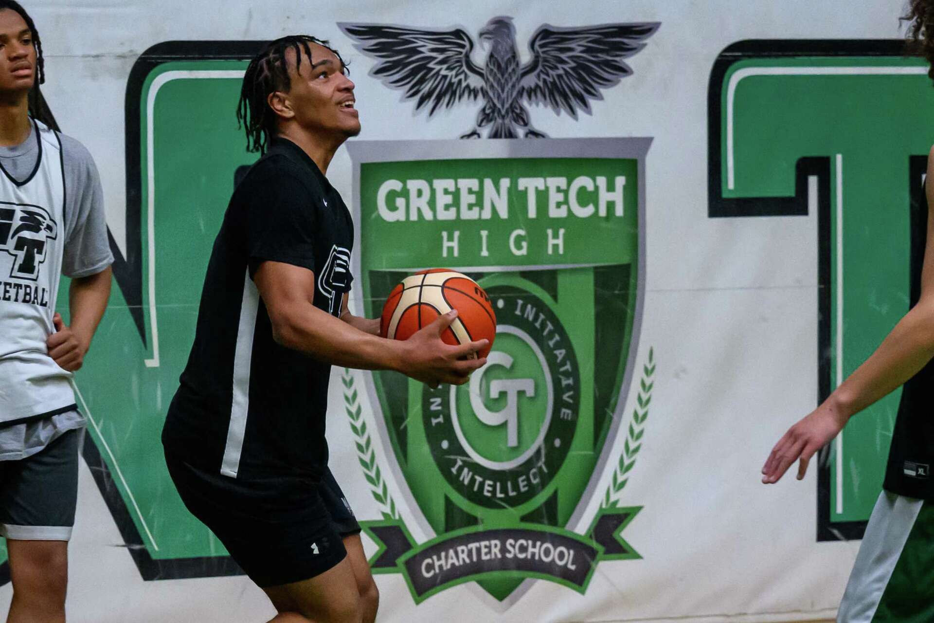 Green Tech Eagles player lining up a shot in front of the school crest