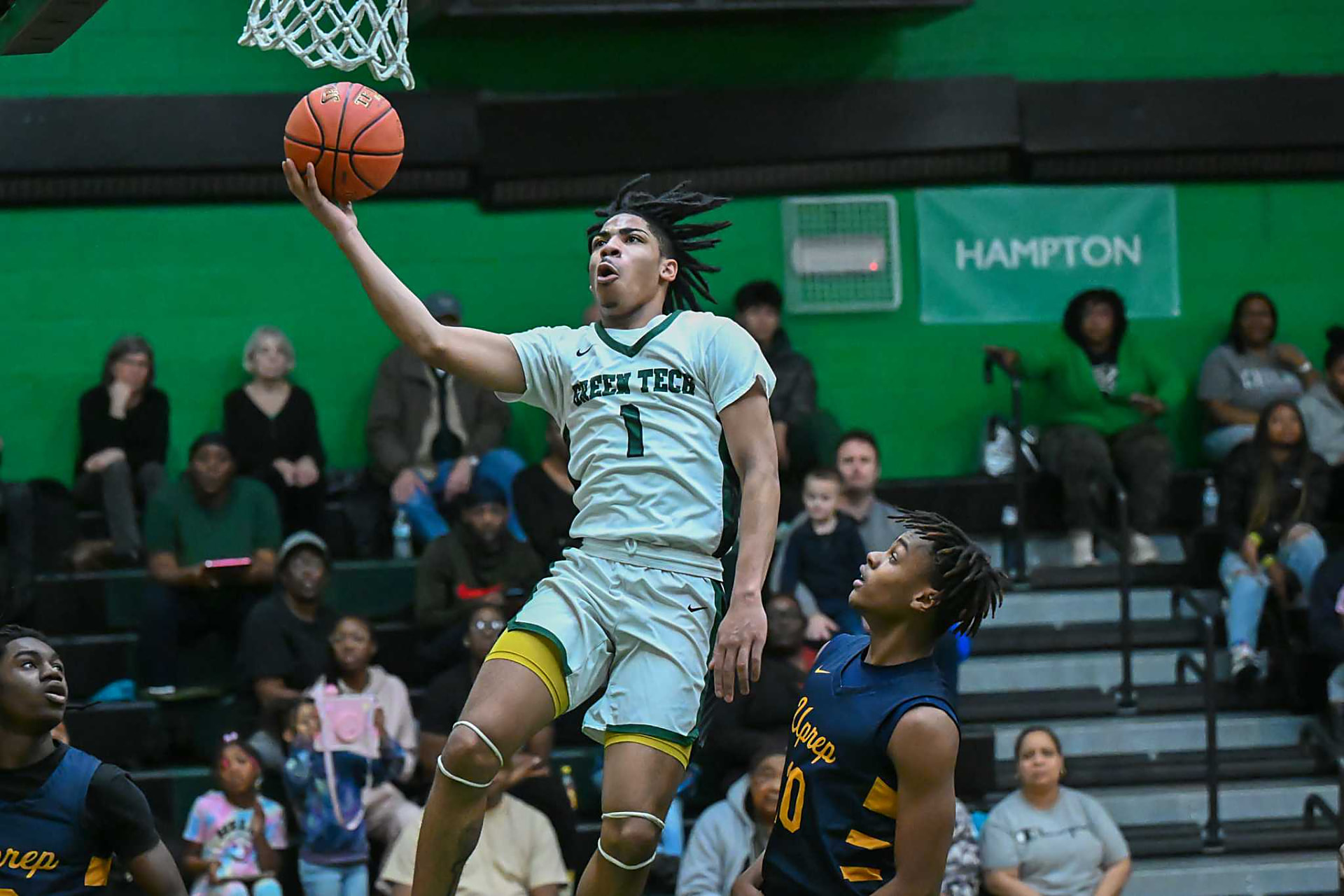 Green Tech Soaring Eagles guard finishing a layup at the rim during a home game