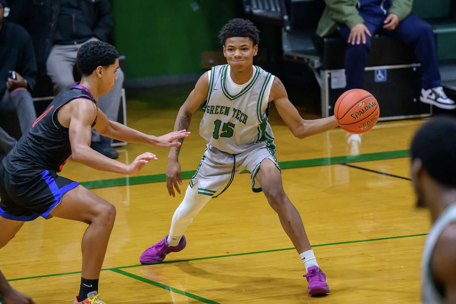 Green Tech High Eagles guard in a white jersey handling the ball against a defender during a home game in Albany, NY