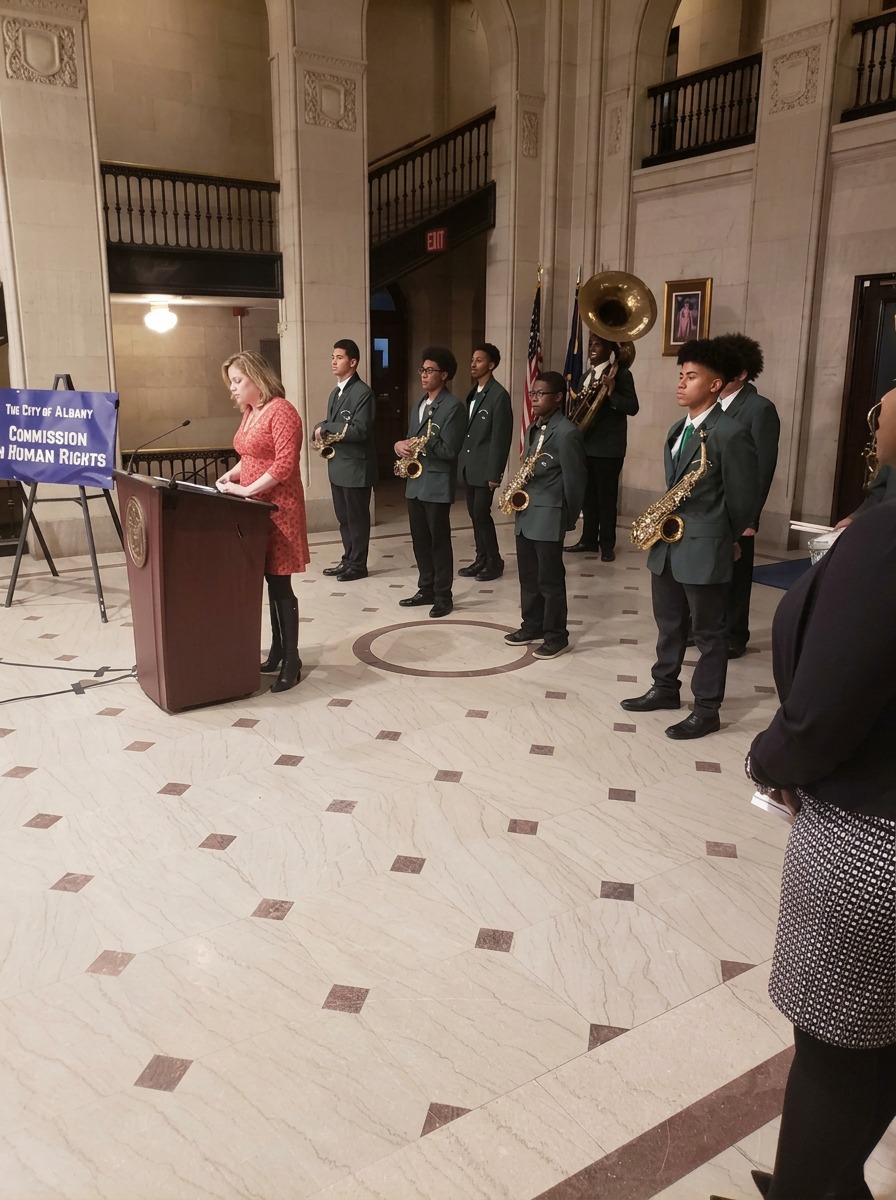 Green Tech High band members standing in uniform with saxophones and sousaphone during a City of Albany ceremony