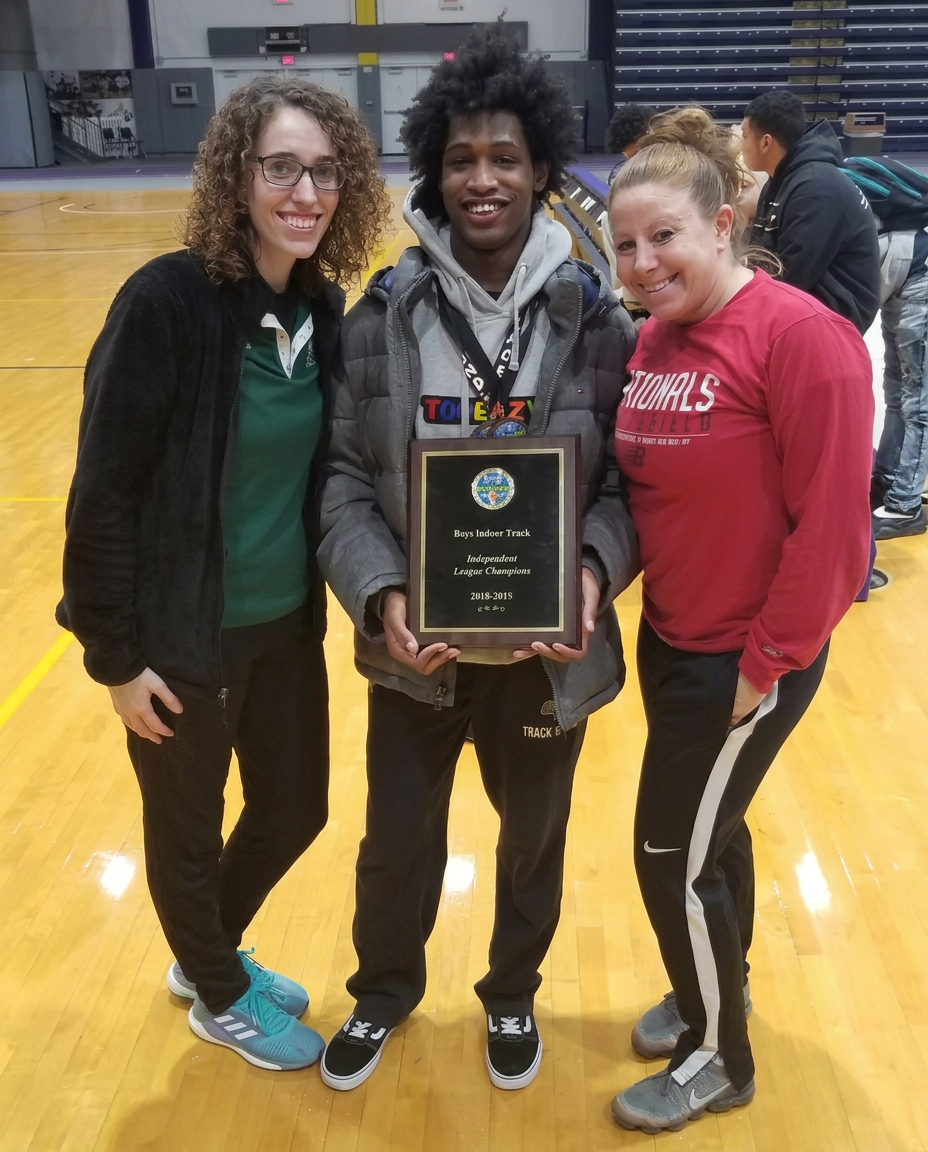 Green Tech track athlete with coaches displaying the Independent League Champions plaque